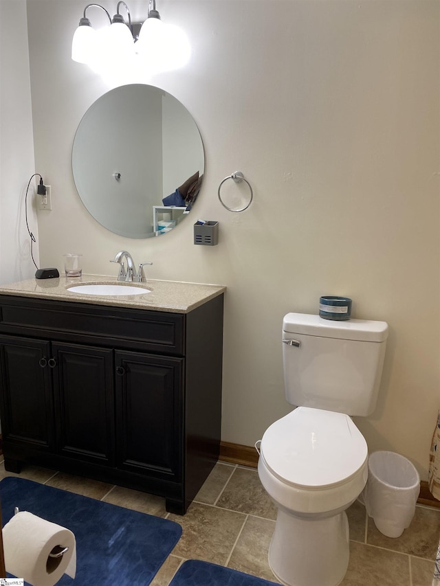 bathroom with toilet, baseboards, and vanity