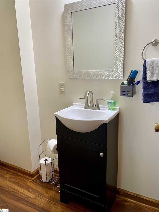 bathroom featuring vanity, baseboards, and wood finished floors