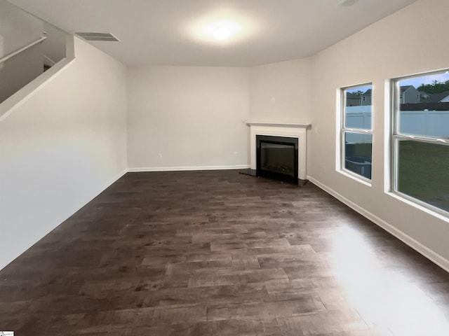 106 Elmhaven Dr, Simpsonville, SC 29681 - unfurnished living room with visible vents, baseboards, a fireplace with raised hearth, and dark wood finished floors