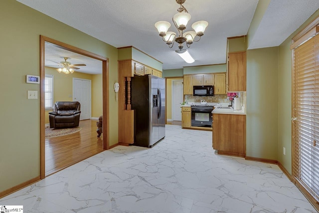 kitchen featuring open floor plan, light countertops, backsplash, marble finish floor, and black appliances
