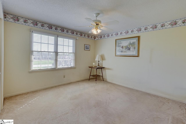 unfurnished room with a textured ceiling, baseboards, a ceiling fan, and carpet