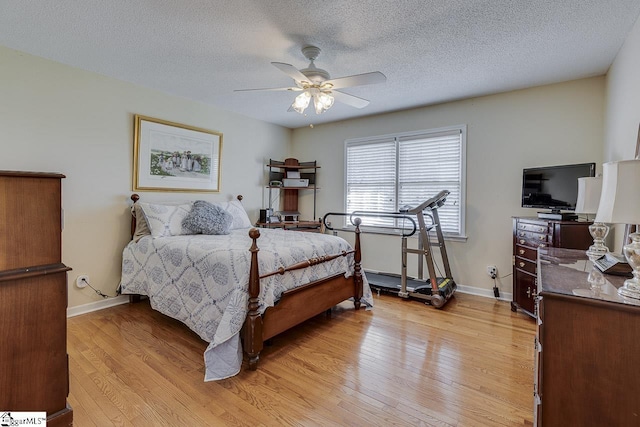 bedroom featuring ceiling fan, a textured ceiling, light wood finished floors, and baseboards