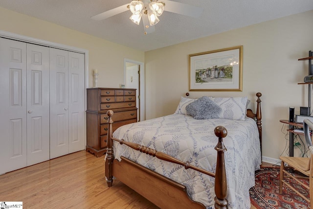 bedroom with a ceiling fan, a closet, light wood-type flooring, and a textured ceiling
