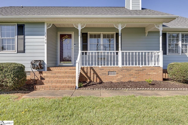 view of exterior entry featuring roof with shingles, covered porch, crawl space, and a chimney