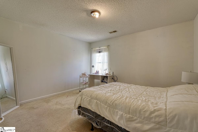 carpeted bedroom with a textured ceiling, baseboards, and visible vents