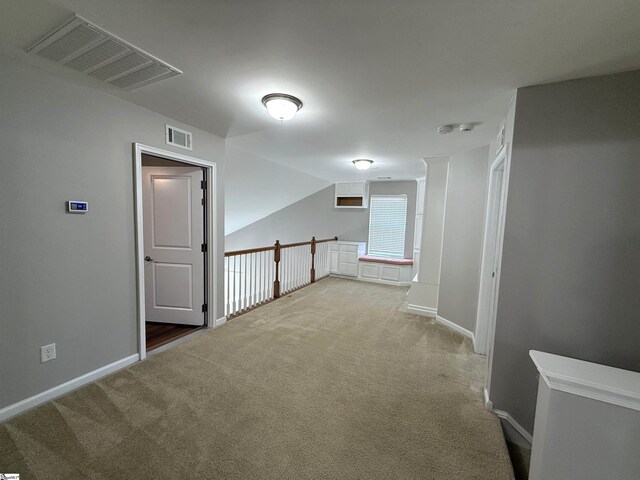 corridor featuring carpet floors, visible vents, and baseboards