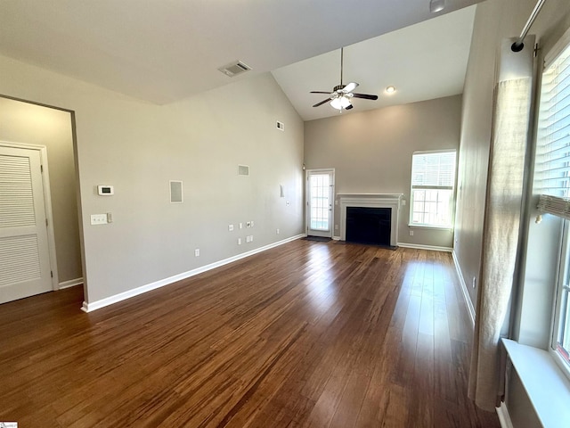 unfurnished living room featuring visible vents, a ceiling fan, dark wood-type flooring, baseboards, and a fireplace