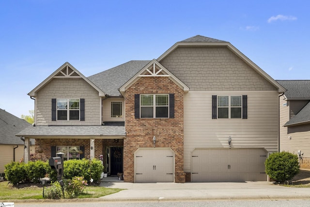 craftsman-style home with concrete driveway, brick siding, an attached garage, and a shingled roof