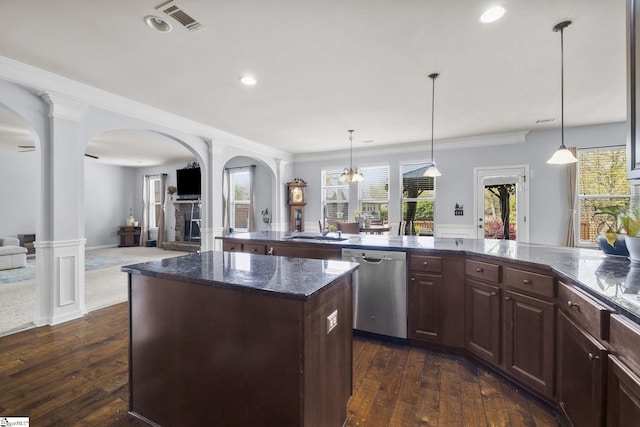 kitchen with a center island, visible vents, arched walkways, dishwasher, and a sink