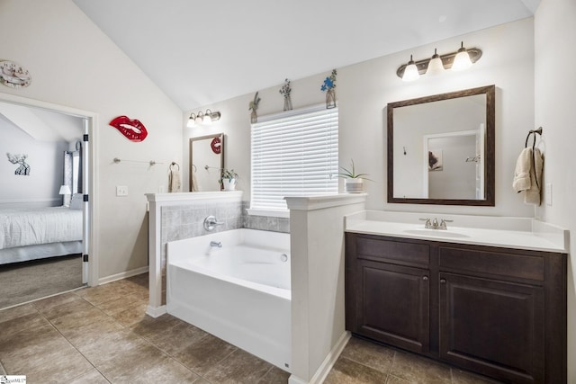 ensuite bathroom featuring a bath, connected bathroom, vanity, tile patterned floors, and lofted ceiling