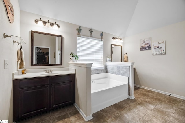 full bathroom with a bath, vanity, vaulted ceiling, and baseboards