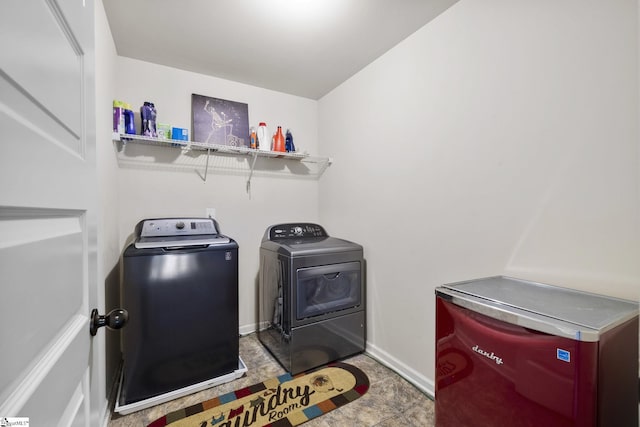 washroom with independent washer and dryer, laundry area, and baseboards