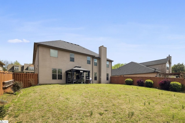 back of property featuring a fenced backyard, a gazebo, and a lawn