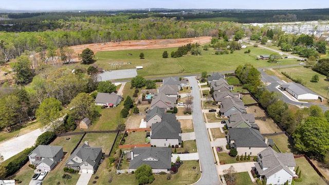 drone / aerial view featuring a forest view and a residential view