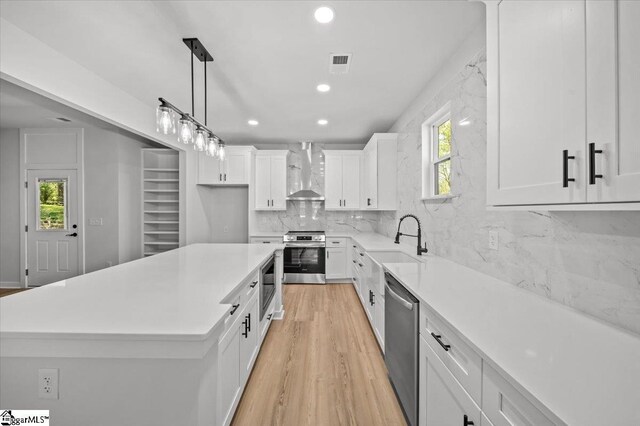 517 Windham Ln, Easley, SC 29642 - kitchen featuring wall chimney range hood, white cabinets, visible vents, stainless steel appliances, and a sink