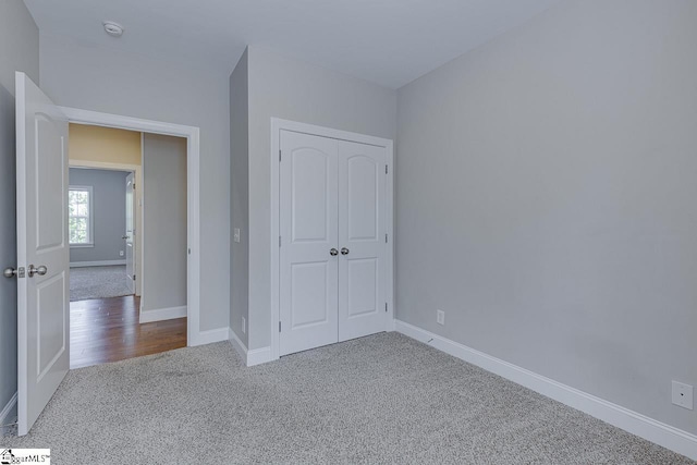 unfurnished bedroom featuring a closet, carpet flooring, and baseboards