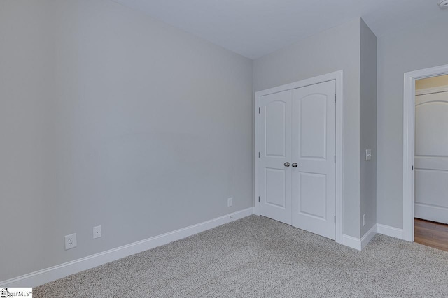 unfurnished bedroom featuring baseboards, a closet, and carpet