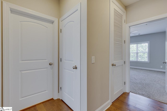 hallway with dark wood-style floors and baseboards