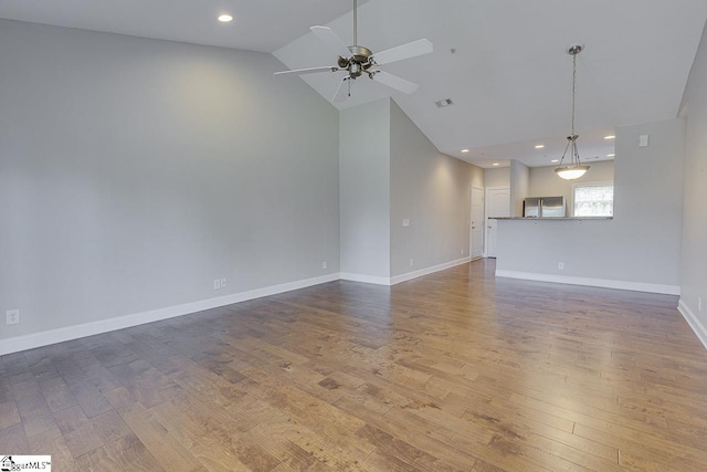 spare room with visible vents, high vaulted ceiling, wood finished floors, and ceiling fan