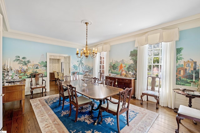 dining space featuring hardwood / wood-style flooring, an inviting chandelier, and crown molding