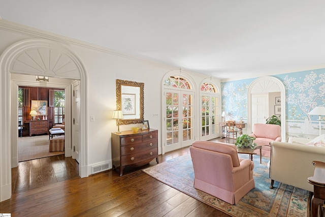 living room with wallpapered walls, visible vents, hardwood / wood-style flooring, and french doors