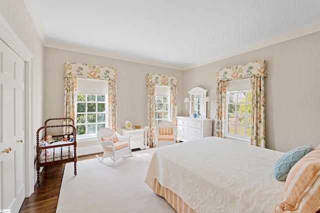 bedroom with crown molding and wood finished floors