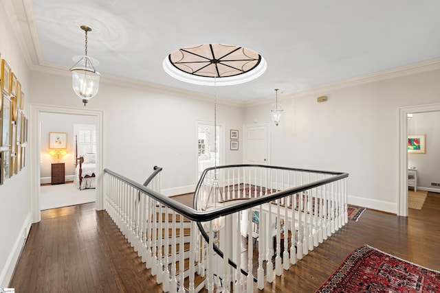 hall featuring plenty of natural light, an upstairs landing, ornamental molding, and wood finished floors