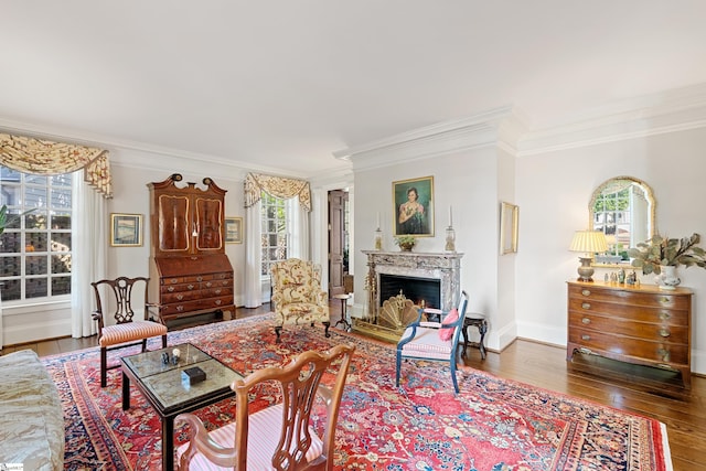 living room featuring crown molding, a premium fireplace, and wood finished floors
