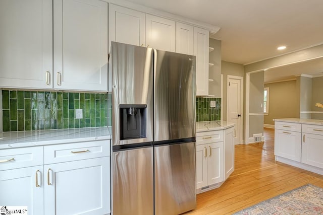 506 Parkview Dr, Spartanburg, SC 29302 - kitchen with visible vents, stainless steel refrigerator with ice dispenser, white cabinetry, light wood finished floors, and light stone countertops