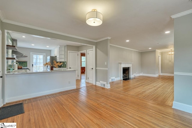 506 Parkview Dr, Spartanburg, SC 29302 - unfurnished living room with a fireplace with flush hearth, light wood-style flooring, a sink, and ornamental molding