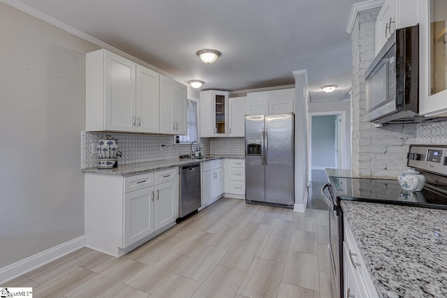 kitchen featuring glass insert cabinets, backsplash, light stone countertops, and stainless steel appliances