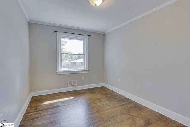 empty room featuring visible vents, crown molding, and wood finished floors