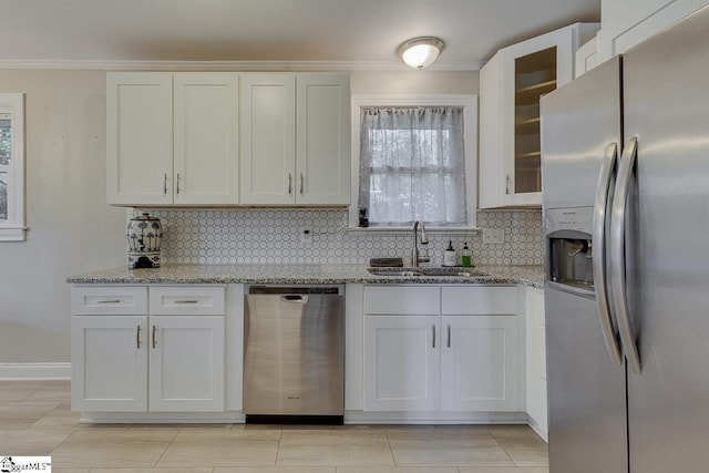 kitchen with white cabinets, tasteful backsplash, a sink, and appliances with stainless steel finishes