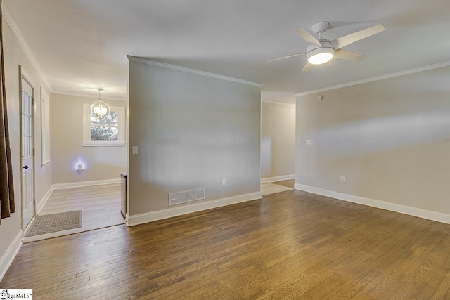 unfurnished room with visible vents, baseboards, crown molding, wood finished floors, and ceiling fan with notable chandelier