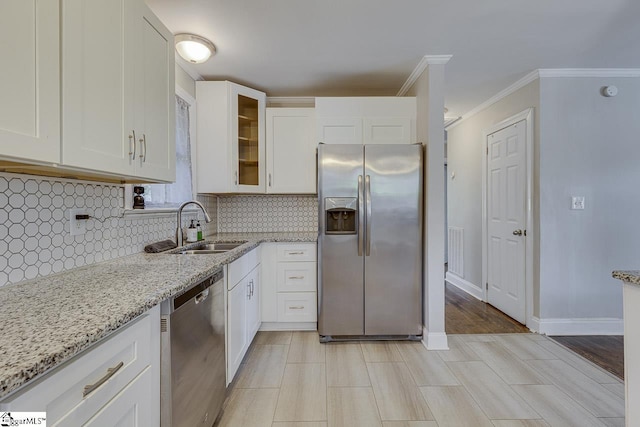 kitchen featuring appliances with stainless steel finishes, light stone counters, and white cabinetry