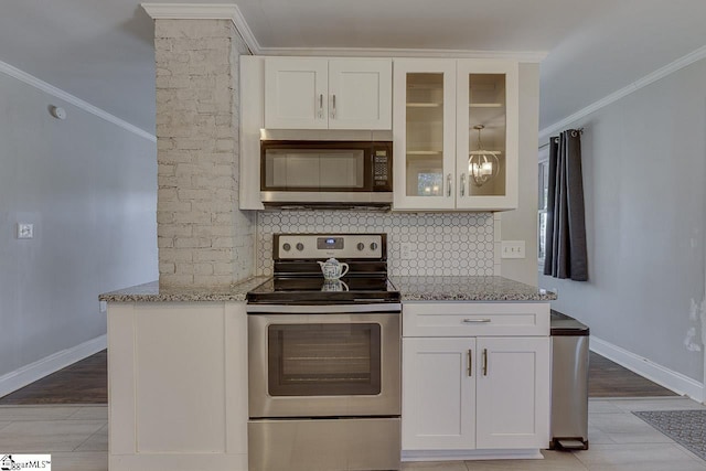 kitchen featuring ornamental molding, appliances with stainless steel finishes, white cabinetry, backsplash, and light stone counters
