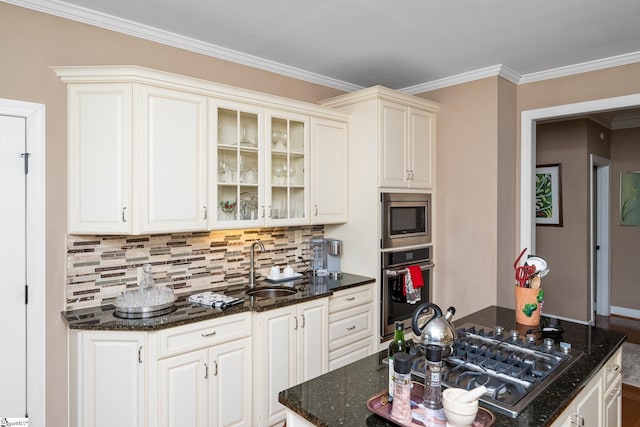kitchen with appliances with stainless steel finishes, glass insert cabinets, dark stone counters, decorative backsplash, and a sink