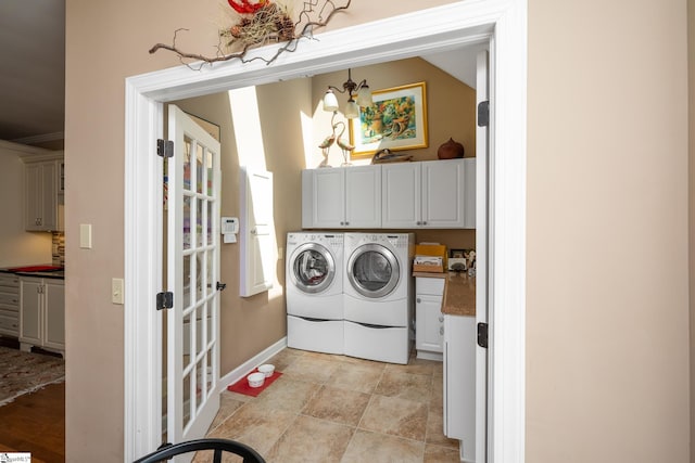 laundry area featuring french doors, cabinet space, and washer and clothes dryer