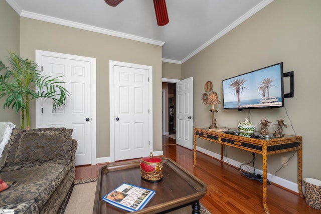 living area with wood finished floors, ceiling fan, and ornamental molding