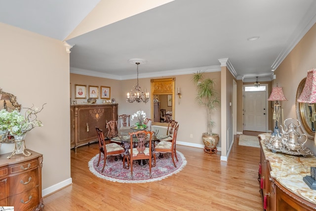 dining space featuring a chandelier, light wood finished floors, and ornamental molding