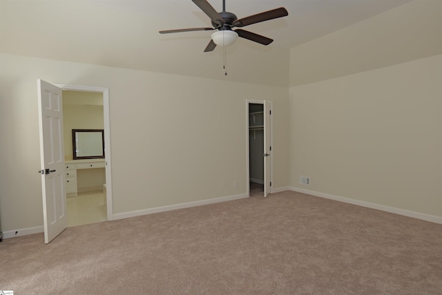 106 Carolina Club Dr, Spartanburg, SC 29306 - unfurnished bedroom with baseboards, ensuite bath, a walk in closet, lofted ceiling, and light colored carpet