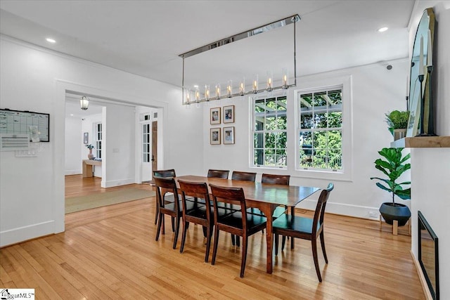 dining space with baseboards, light wood-type flooring, and recessed lighting