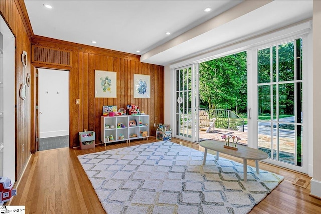 unfurnished room featuring wood walls, recessed lighting, visible vents, and wood finished floors
