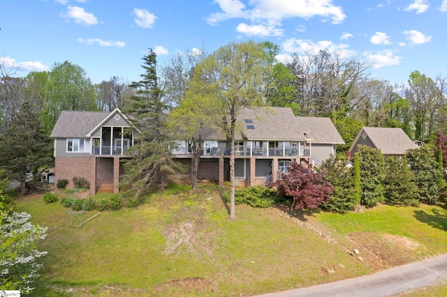 exterior space with a sunroom, a yard, a wooden deck, and stairway