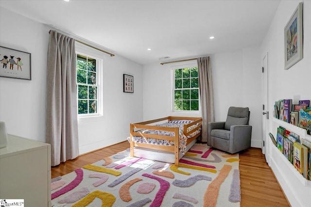 bedroom featuring recessed lighting, multiple windows, baseboards, and wood finished floors