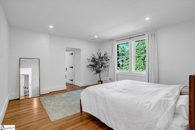 bedroom featuring baseboards, recessed lighting, and wood finished floors