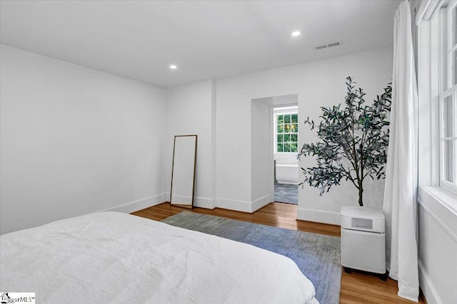 bedroom featuring visible vents, baseboards, recessed lighting, and wood finished floors