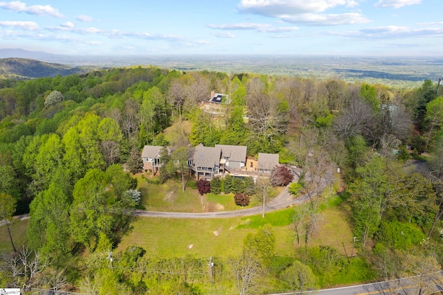 birds eye view of property featuring a forest view