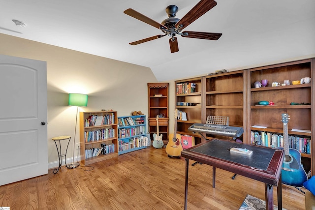 office with baseboards, a ceiling fan, vaulted ceiling, and wood finished floors