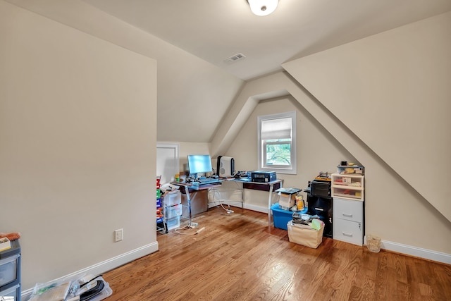 office area with visible vents, baseboards, vaulted ceiling, and wood finished floors
